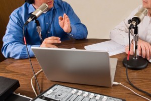 iStock_000003868197XSmall one man speaking into a microphone with computer in front of him