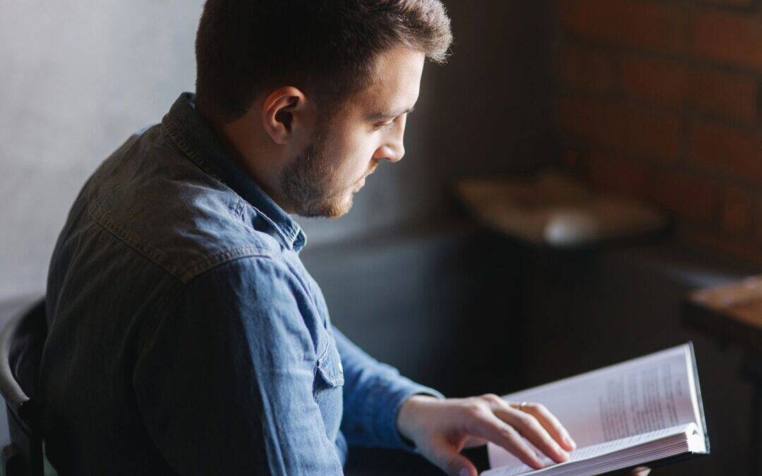 photo of man reading a novel
